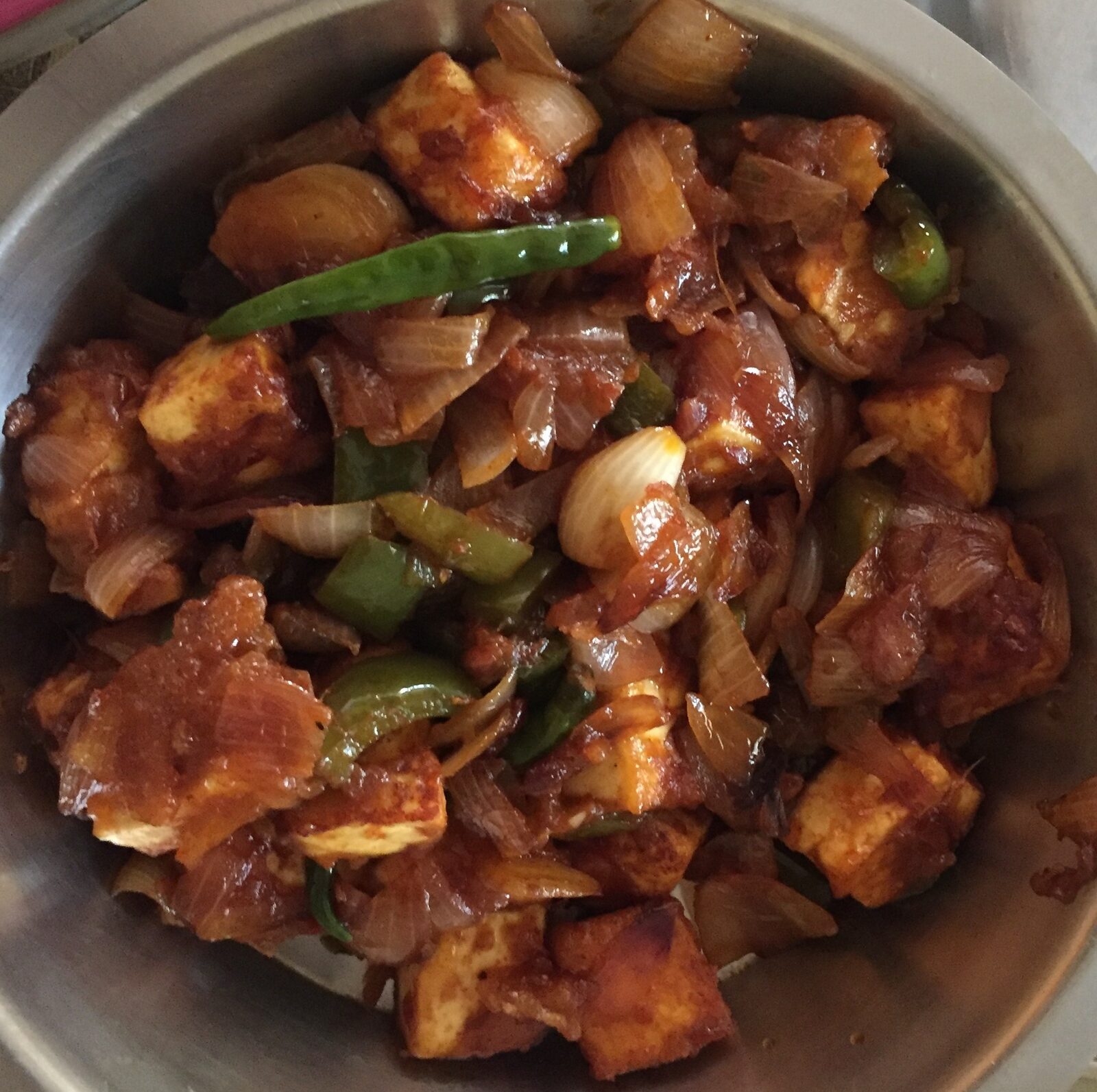 Indo-Chinese chilli paneer tossed in spiced sauce with peppers and onions