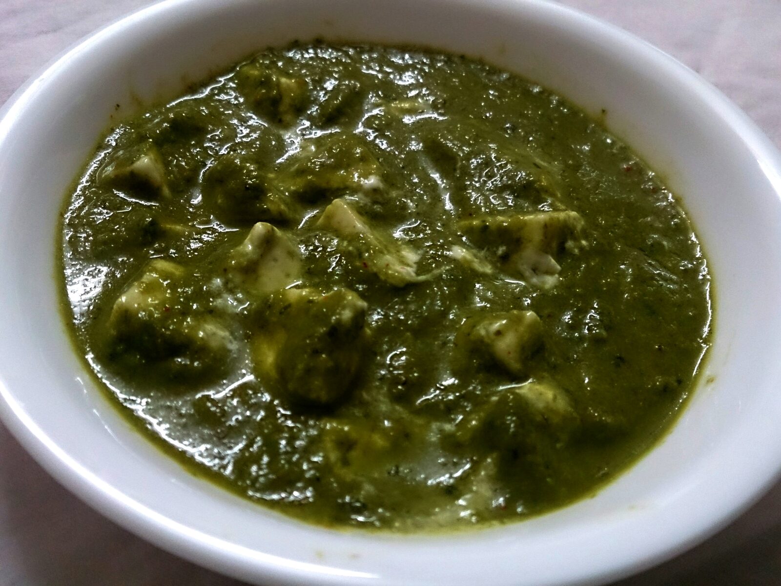 Palak paneer, soft paneer cubes simmered in a creamy spiced spinach gravy